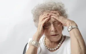 elderly woman touching her head