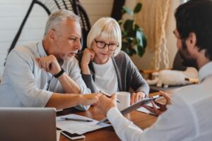 During a consultation with an attorney, a man and woman learn how much it costs to hire a nursing home abuse lawyer in Georgia.